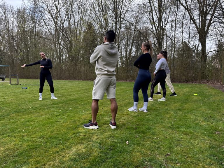 Groep Groep mensen in een park die deelnemen aan een sportieve activiteit.
